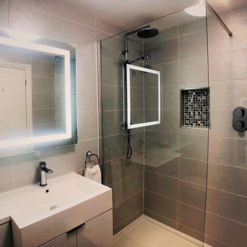 Walk-in rain shower with illuminated mirror